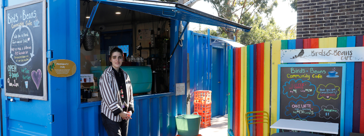 Photograph of barista standing outside the Birds and Beans Cafe in Reservoir, a social enterprise by the Reservoir Neighbourhood House